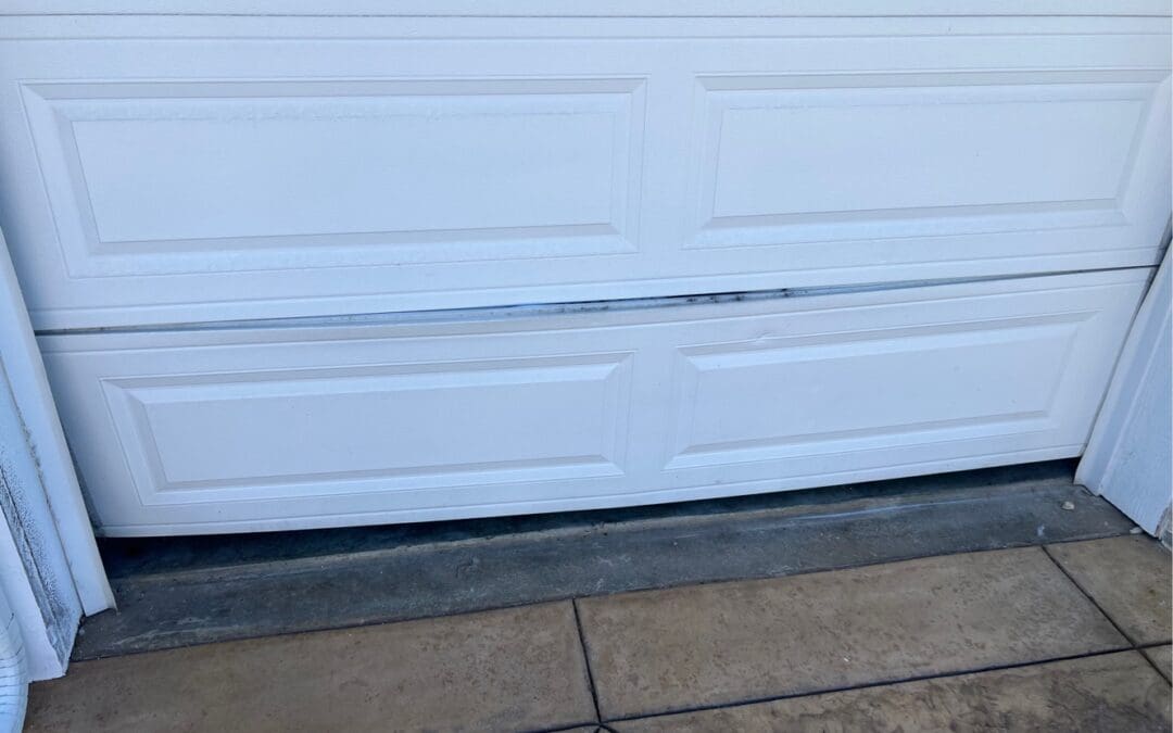 A Valencia garage door repair technician's high-quality work, featuring professional service and inspection of blue torsion springs and overhead tracks by Archway Garage Doors.